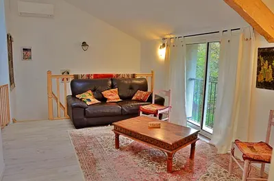 a living room with a leather couch and a coffee table at Violette in Saint-Pierre-de-Trivisy