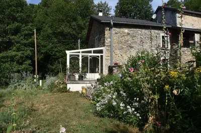 an old stone house with a garden and flowers at Violette in Saint-Pierre-de-Trivisy