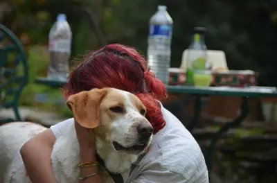 a woman with red hair and a dog on her lap at Violette in Saint-Pierre-de-Trivisy
