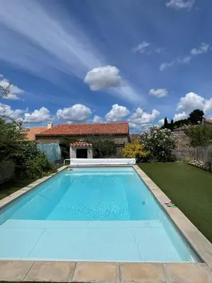 a swimming pool in front of a house at Le Plô in Couffoulens