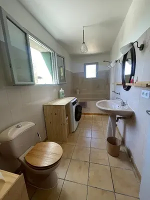 a bathroom with a toilet and a sink at Le Plô in Couffoulens