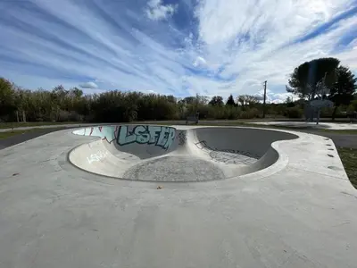 a skate park with a skateboard ramp with graffiti at Le Plô in Couffoulens
