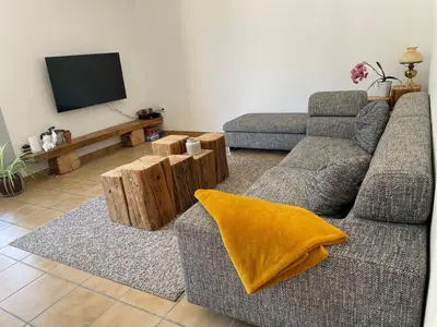 a living room with a couch and a tv at Le Plô in Couffoulens