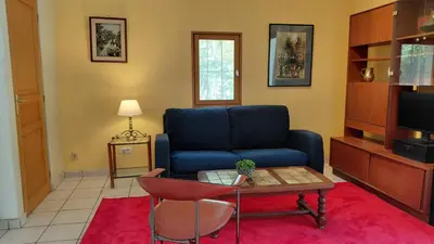 a living room with a blue couch and a table at Gite Mimosa in South of France - Entire Holiday Home in Sainte-Vallière