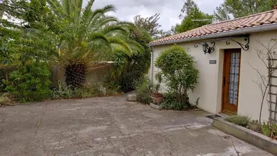 a small white house with a palm tree in front of it at Gite Mimosa in South of France - Entire Holiday Home in Sainte-Vallière
