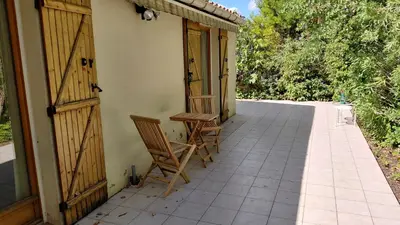 a pair of chairs sitting on the porch of a house at Gite Mimosa in South of France - Entire Holiday Home in Sainte-Vallière