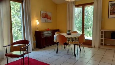 a dining room with a table and chairs and windows at Gite Mimosa in South of France - Entire Holiday Home in Sainte-Vallière