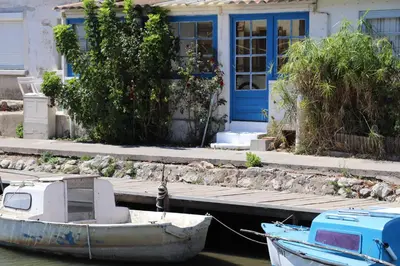 a boat is docked in front of a house at Authentic fisherman's house Maison de pêcheur authentique in Port-la-Nouvelle