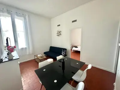 a living room with a black table and chairs at Appartement de type 3 de 65 m2 Narbonne centre in Narbonne