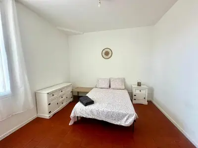 a bedroom with a bed and two dressers and a clock at Appartement de type 3 de 65 m2 Narbonne centre in Narbonne