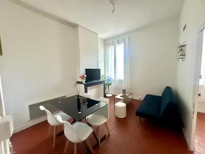 a living room with a black table and white chairs at Appartement de type 3 de 65 m2 Narbonne centre in Narbonne