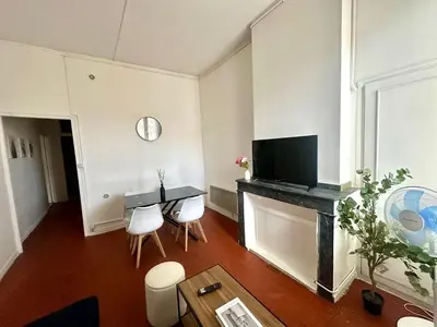 a living room with a table and a tv at Appartement de type 3 de 65 m2 Narbonne centre in Narbonne