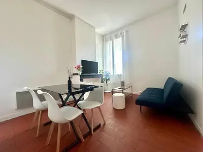 a living room with a dining room table and chairs at Appartement de type 3 de 65 m2 Narbonne centre in Narbonne