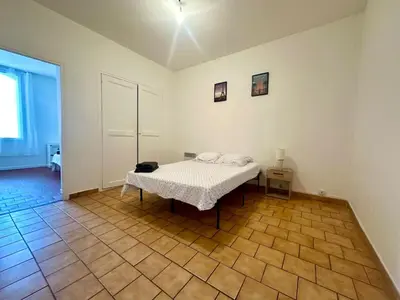 a bedroom with a bed and a wooden floor at Appartement de type 3 de 65 m2 Narbonne centre in Narbonne