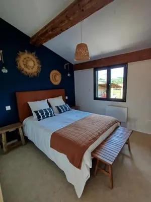 a bedroom with a large bed and a window at Les Tournesols gîte en pleine nature in Hounoux