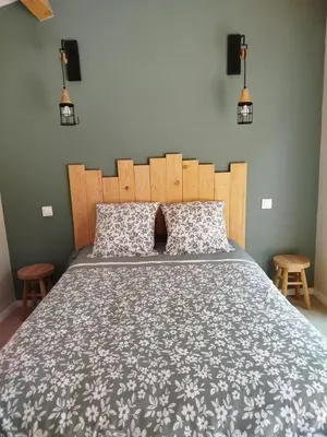 a bedroom with a large bed and two chairs at Les Tournesols gîte en pleine nature in Hounoux