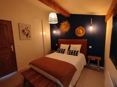 a bedroom with a bed and a chandelier at Les Tournesols gîte en pleine nature in Hounoux