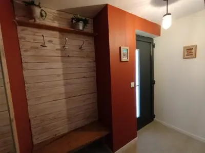 a hallway with a wooden wall with hangers at Les Tournesols gîte en pleine nature in Hounoux