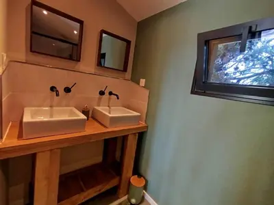 a bathroom with two white sinks and a window at Les Tournesols gîte en pleine nature in Hounoux