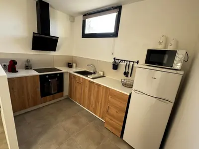 a kitchen with a white refrigerator and a sink at Entre Campagne et Ville in Marcorignan