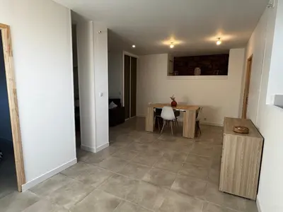 a living room with a table and a dining room at Entre Campagne et Ville in Marcorignan