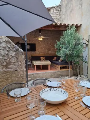 a wooden table with an umbrella on a patio at La Casita Sigean in Sigean