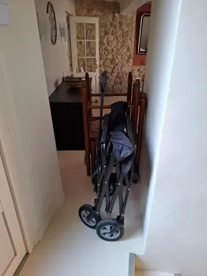 a stroller in the hallway of a kitchen with a table at La Casita Sigean in Sigean