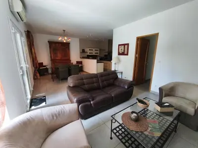 a living room with a leather couch and a table at Le Gîte de JC in Homps
