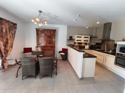 a kitchen with a table and chairs in a kitchen at Le Gîte de JC in Homps