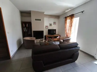 a living room with a couch and a television at Le Gîte de JC in Homps