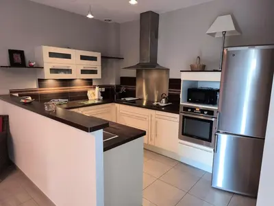a kitchen with a stainless steel refrigerator and appliances at Le Gîte de JC in Homps