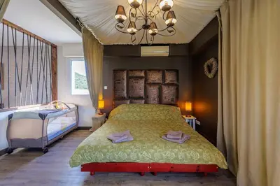 a bedroom with a bed and a chandelier at villa sophora - piscine toboggan aquatique privée in Conilhac-Corbières