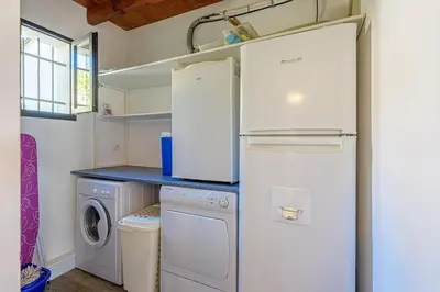 a kitchen with a refrigerator and a washer and dryer at villa sophora - piscine toboggan aquatique privée in Conilhac-Corbières