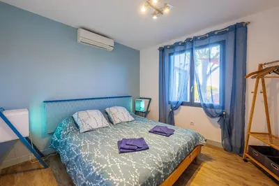 a blue bedroom with a bed with purple towels on it at villa sophora - piscine toboggan aquatique privée in Conilhac-Corbières