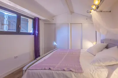 a bedroom with a large bed with a window at villa sophora - piscine toboggan aquatique privée in Conilhac-Corbières