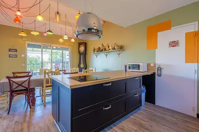 a kitchen with a counter and a dining room at villa sophora - piscine toboggan aquatique privée in Conilhac-Corbières