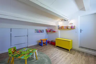a room with a classroom with a table and a chair at villa sophora - piscine toboggan aquatique privée in Conilhac-Corbières