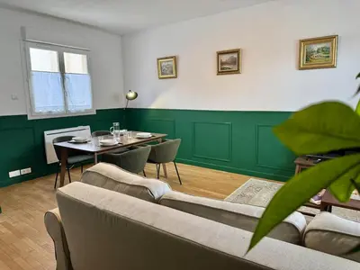 a living room with a table and a green wall at Le Mahuzies 6 - Hypercentre in Castres