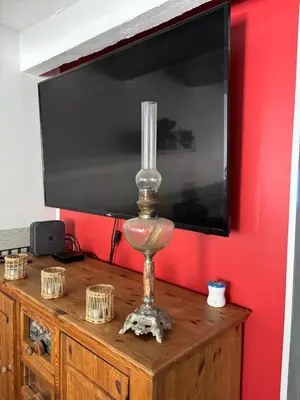 a lamp sitting on top of a dresser with a television at maison Odjas in Saint-Laurent-de-la-Cabrerisse