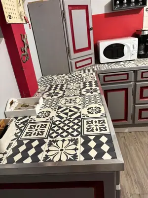 a kitchen with a table with a black and white counter top at maison Odjas in Saint-Laurent-de-la-Cabrerisse