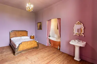 a bedroom with a bed and a tub and a sink at Château de L'Encastre in Revel