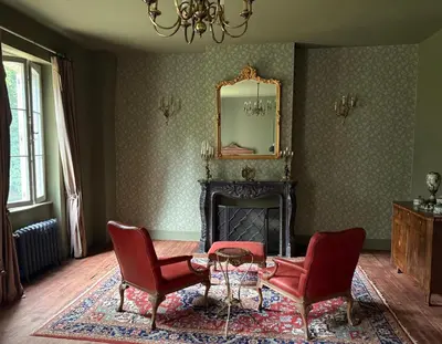 a living room with two red chairs and a mirror at Château de L'Encastre in Revel