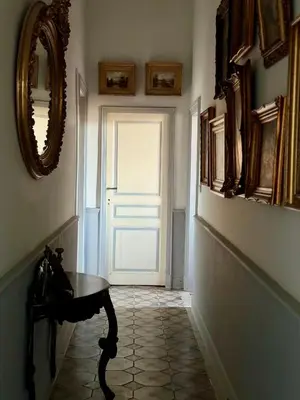 a hallway with a door and a table and a mirror at Château de L'Encastre in Revel