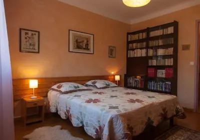 a bedroom with a bed and a book shelf at Gîte du Four à Chaux in Quillan