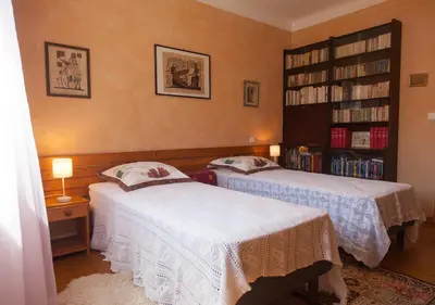a bedroom with two beds and a book shelf at Gîte du Four à Chaux in Quillan