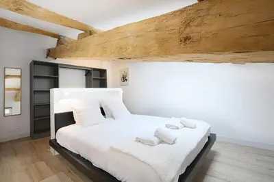 a bedroom with a white bed with towels on it at Confort & espace avec climatisation - T4 central in Villefranche-de-Lauragais
