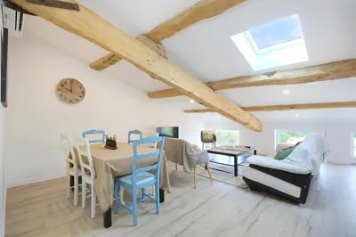 a dining room with a table and chairs and a clock at Confort & espace avec climatisation - T4 central in Villefranche-de-Lauragais