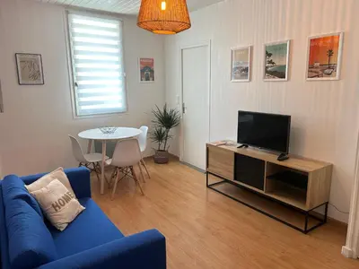 a living room with a blue couch and a tv at appartement hyper centre in Narbonne