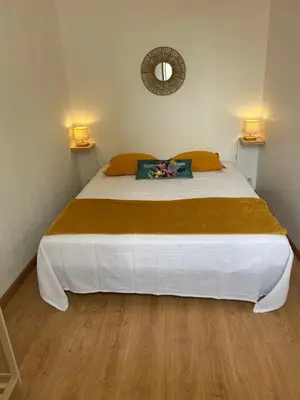 a bedroom with a large white bed with a mirror at appartement hyper centre in Narbonne