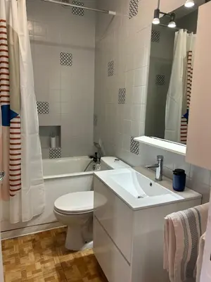 a white bathroom with a toilet and a sink at appartement hyper centre in Narbonne